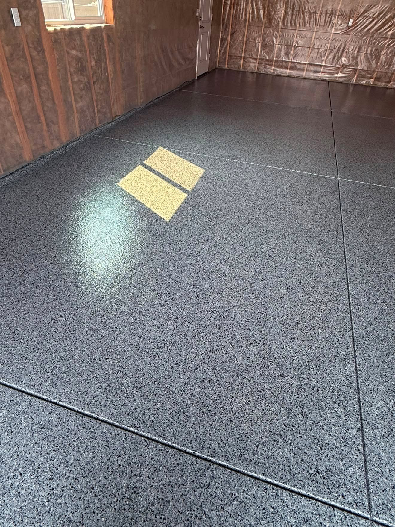 Close-up of a glossy grey flake epoxy garage floor